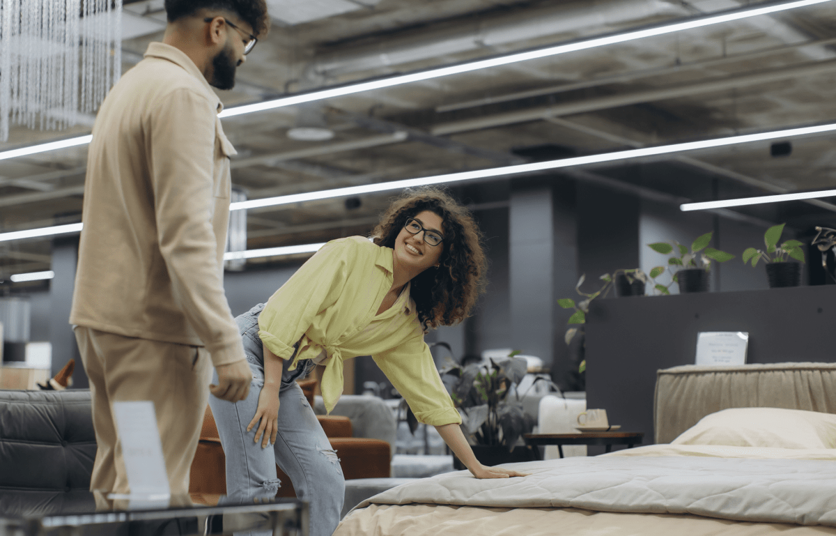 Couple testing a mattress while considering design and unique sizing needs.