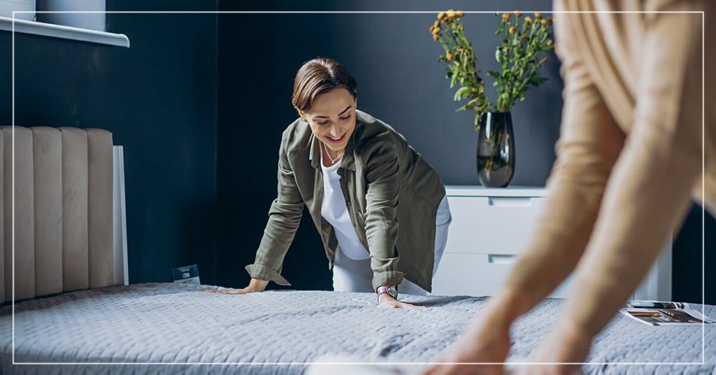 Customer testing firmness of mattress